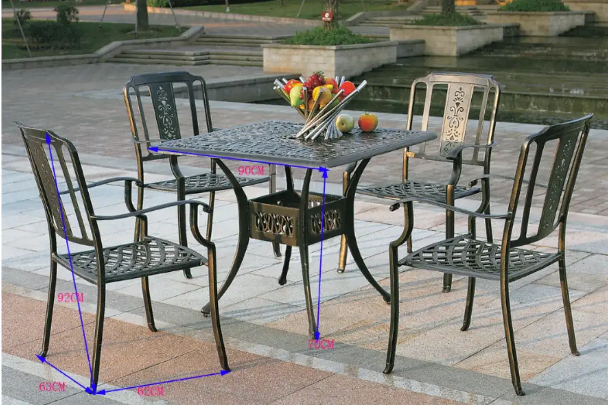 Bộ bàn ghế sắt ngoài trời gồm bốn ghế và bàn vuông đặt trên nền sân lát gạch