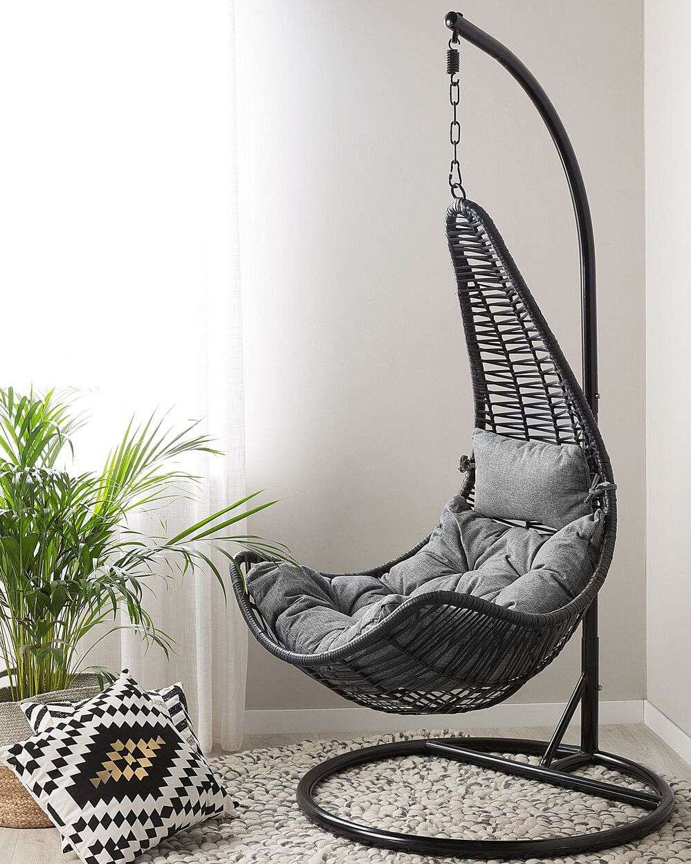 Modern interior featuring a woven swing chair and soft cushions