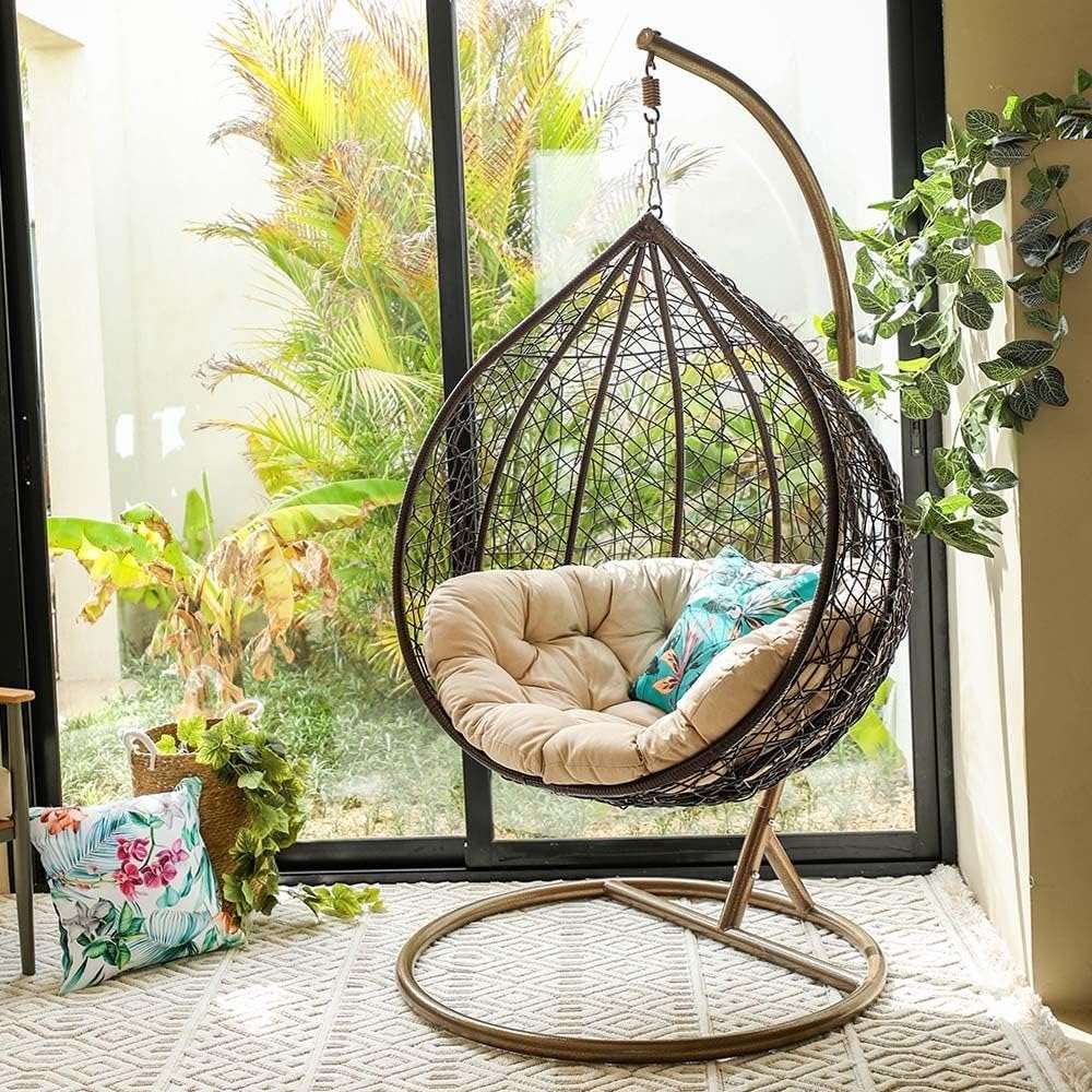 Swing chair placed by the window with natural light streaming in