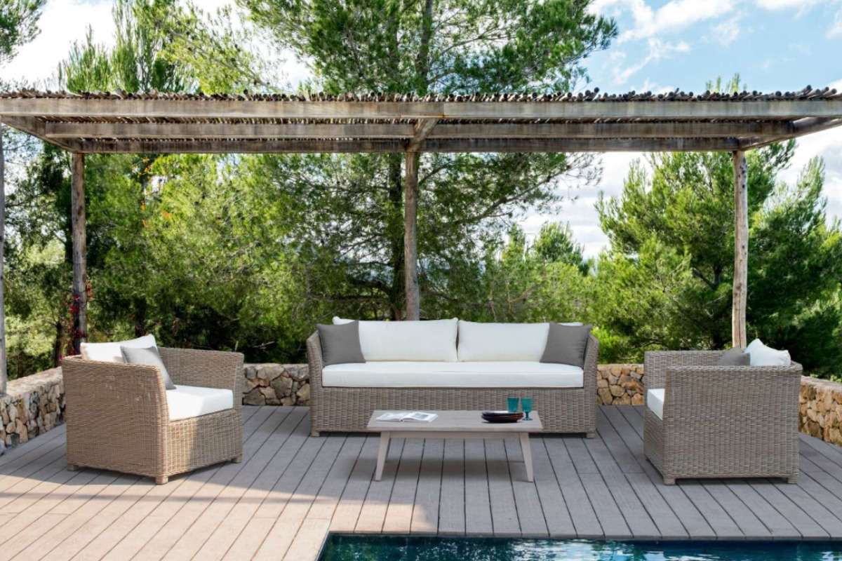 Outdoor 4-seater sofa set made from rope or HDPE rattan under a shaded pergola surrounded by greenery.