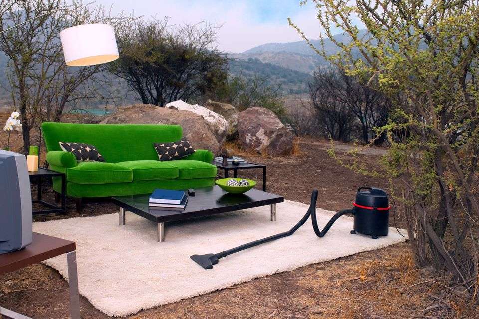 Green sofa placed outdoors amidst natural surroundings