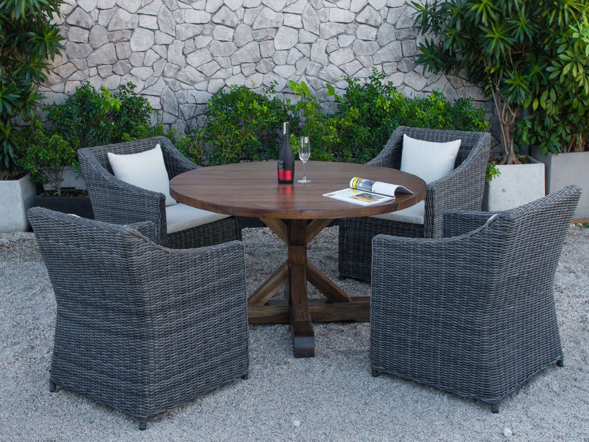 Dining area with gray wicker chairs and lush greenery surroundings