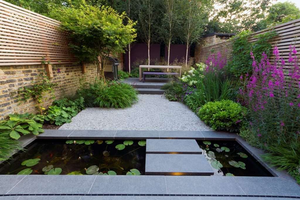 Compact outdoor area with vibrant plants and a decorative water feature