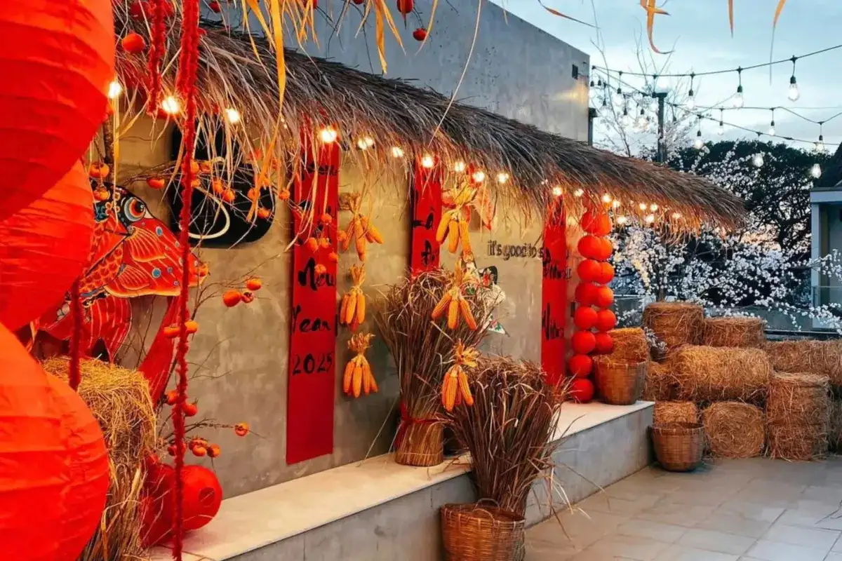 Tiểu cảnh Tết mộc mạc với đèn lồng đỏ, bắp khô, kiện rơm, giỏ mây và mái lá