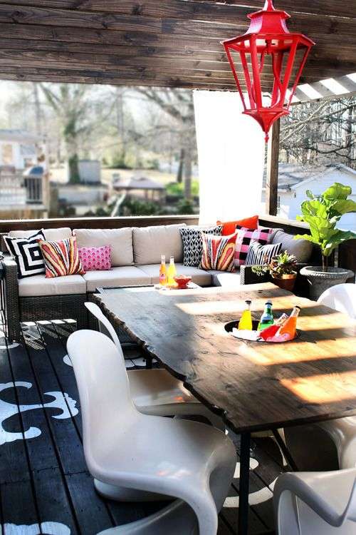 Patio design featuring a long wooden table and decorative lighting