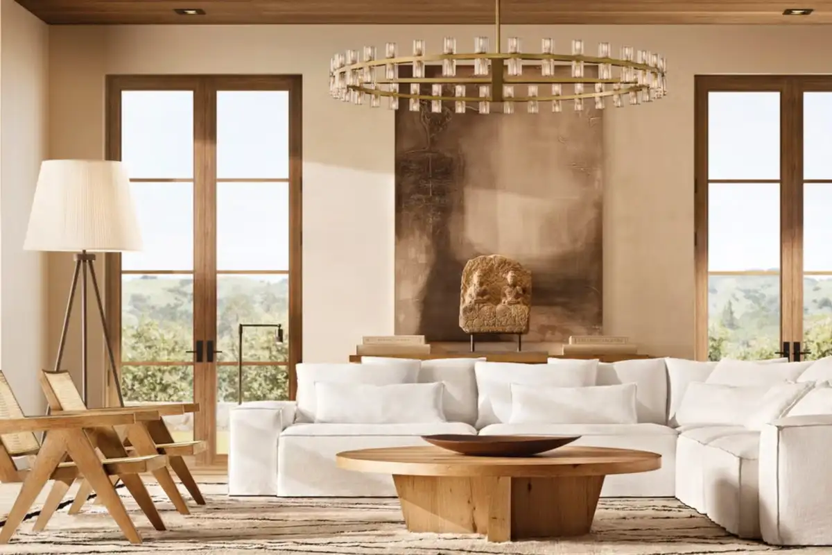 A luxurious living room with a white sectional sofa, round wooden coffee table, floor lamp, chandelier, and large windows with natural light.