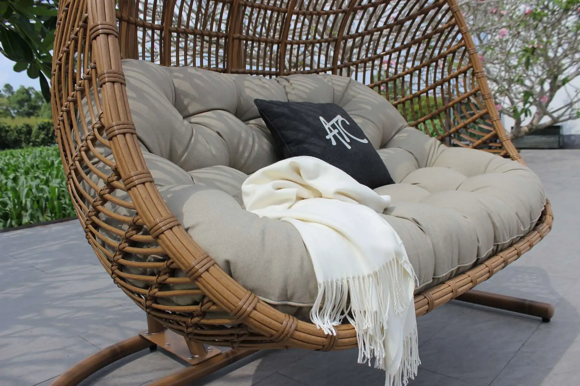 Close-up of thick cushions and spacious seating on a synthetic rattan double egg chair