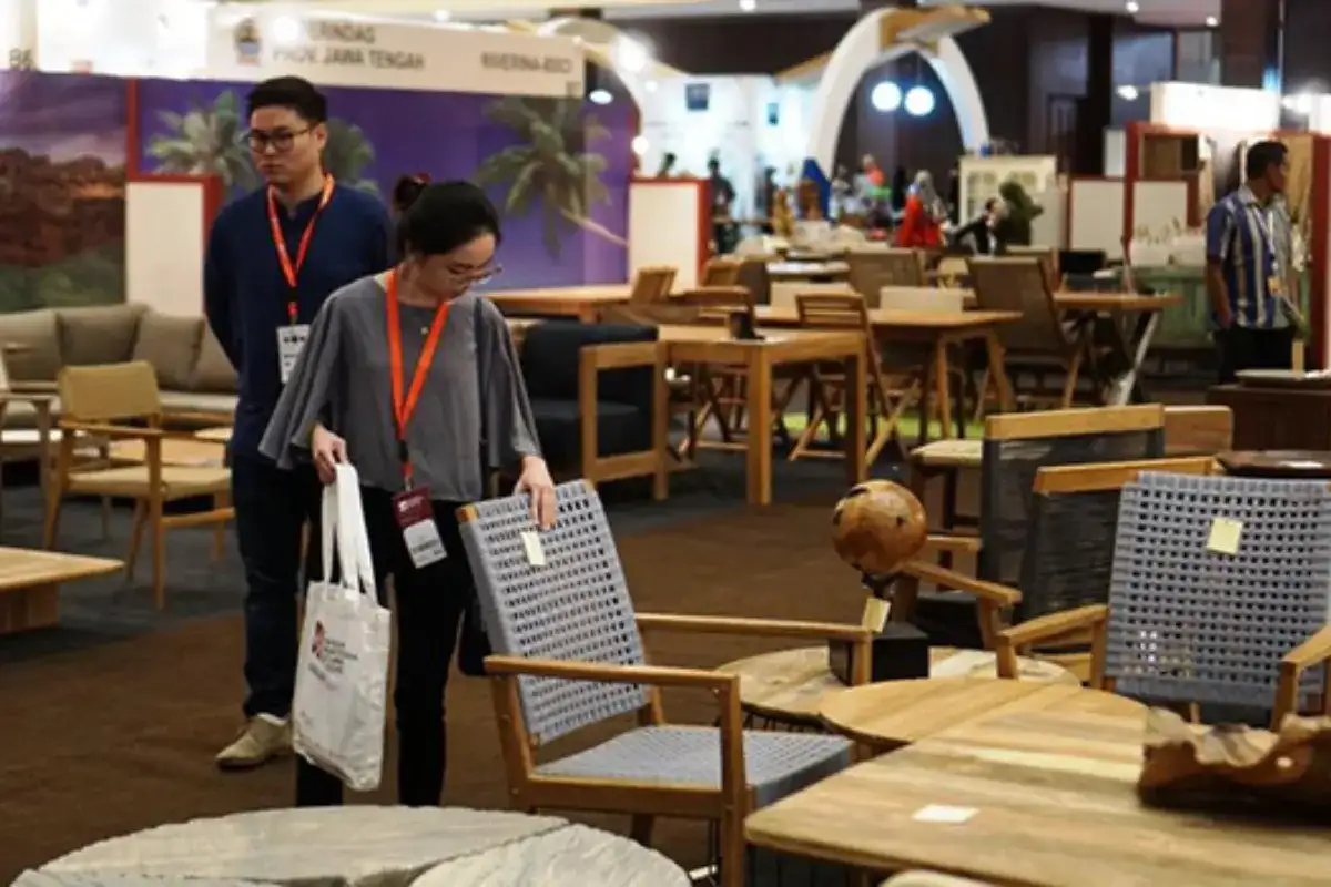 Khách tham quan kiểm tra mẫu bàn ghế ngoài trời tại triển lãm nội thất