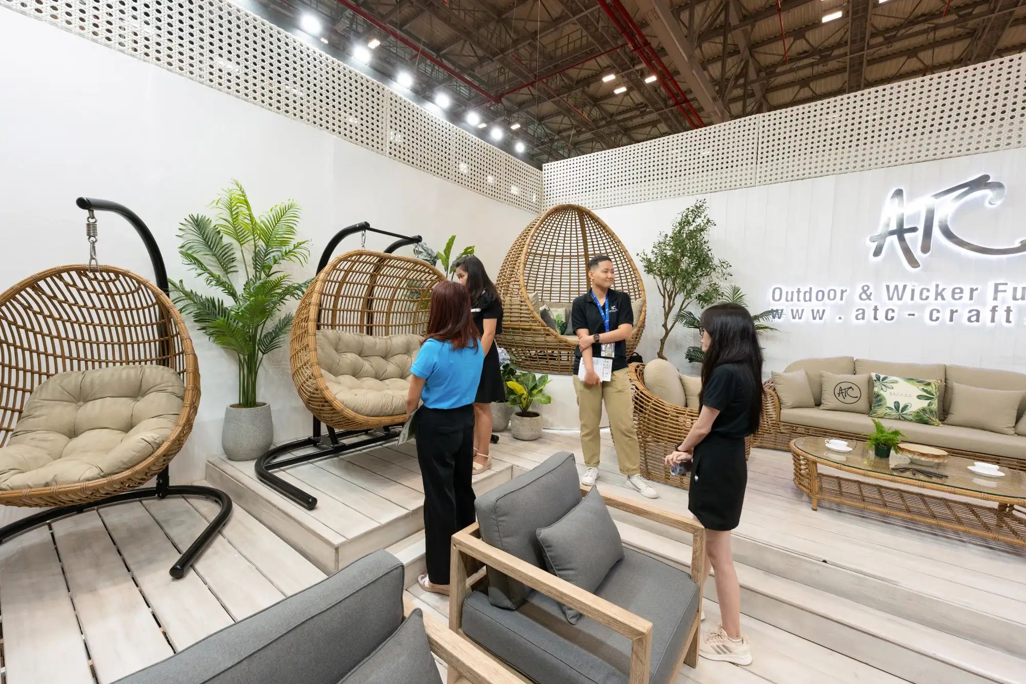 Buyers meeting manufacturers at a furniture exhibition booth during a trade fair.