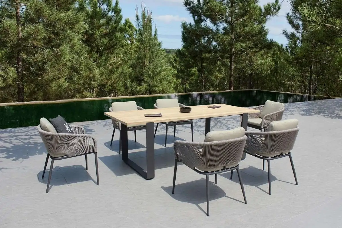 Modern outdoor dining set with wooden rectangular table and six rope chairs by the poolside.