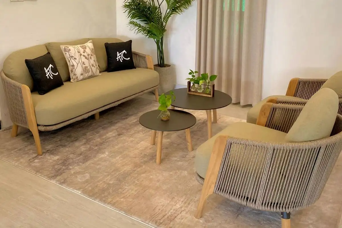 Cozy living room with rope sofa set, wooden frame armchairs, and round coffee tables.