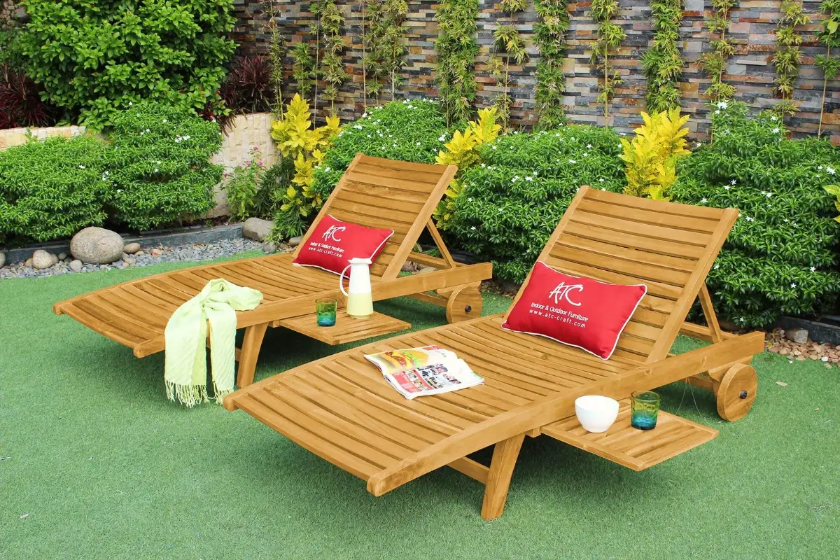 Two teak wood sun loungers on green grass