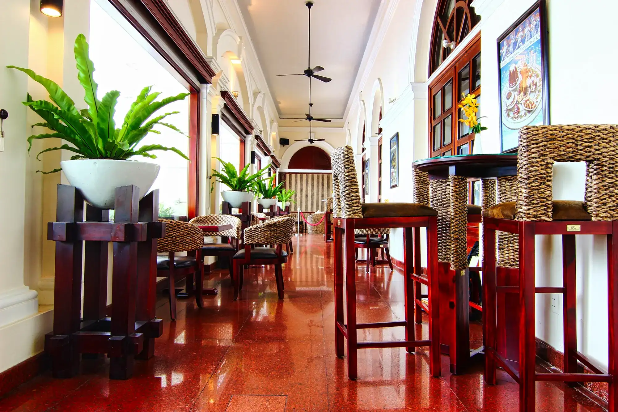 Handwoven water hyacinth chairs and tables placed along a bright indoor walkway, highlighting natural textures and neutral tones