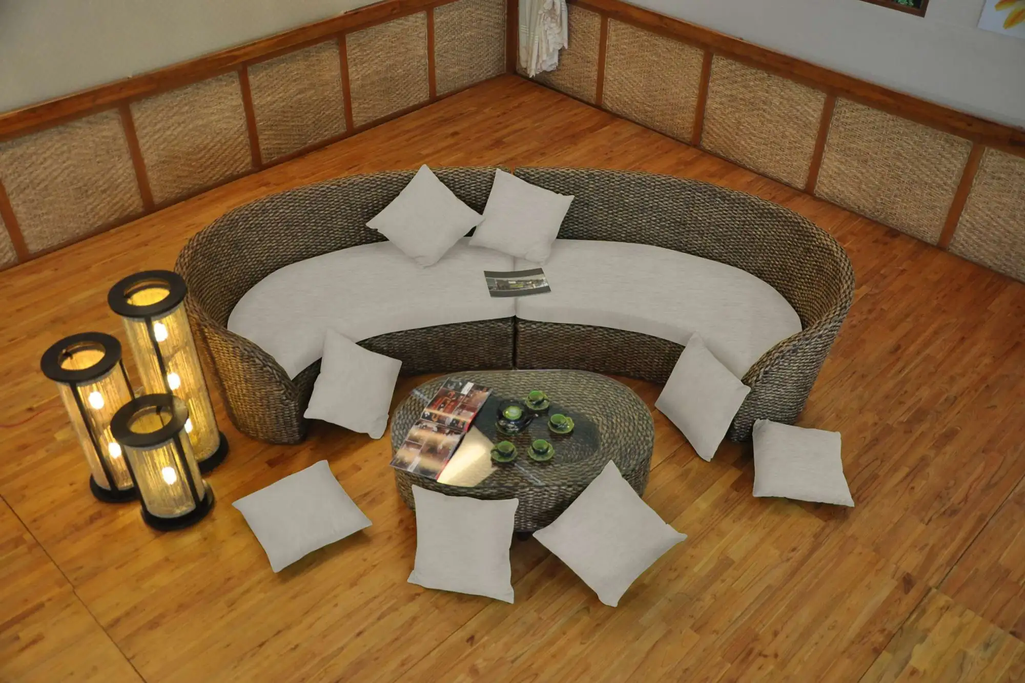 MOLOKINI water hyacinth curved sectional sofa arranged with matching coffee table and loose cushions in a warm indoor setting.