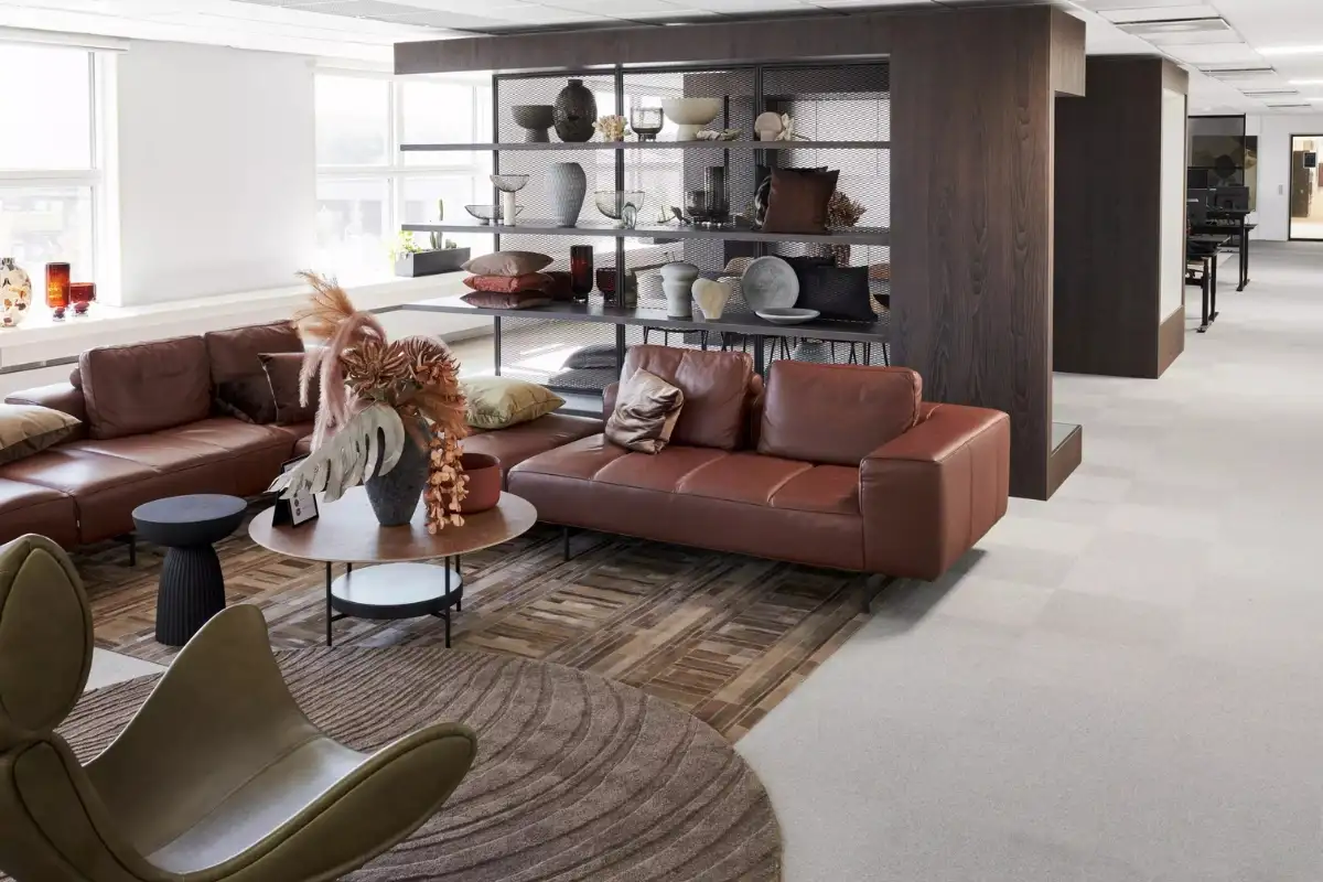 Phòng khách BoConcept với sofa da nâu, ghế lounge hiện đại, bàn trà và kệ mở