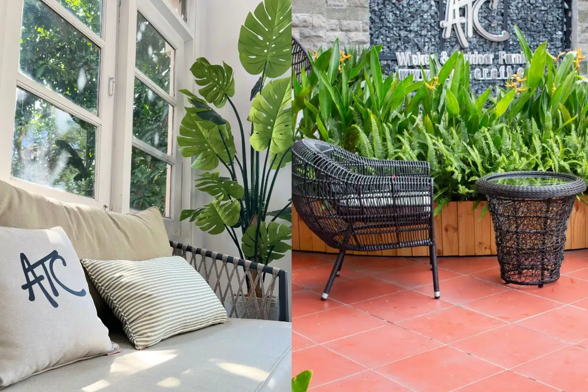 Phòng khách trong nhà với sofa mây bên cửa sổ và không gian sân ngoài trời có ghế đan màu đen, bàn phụ và cây xanh