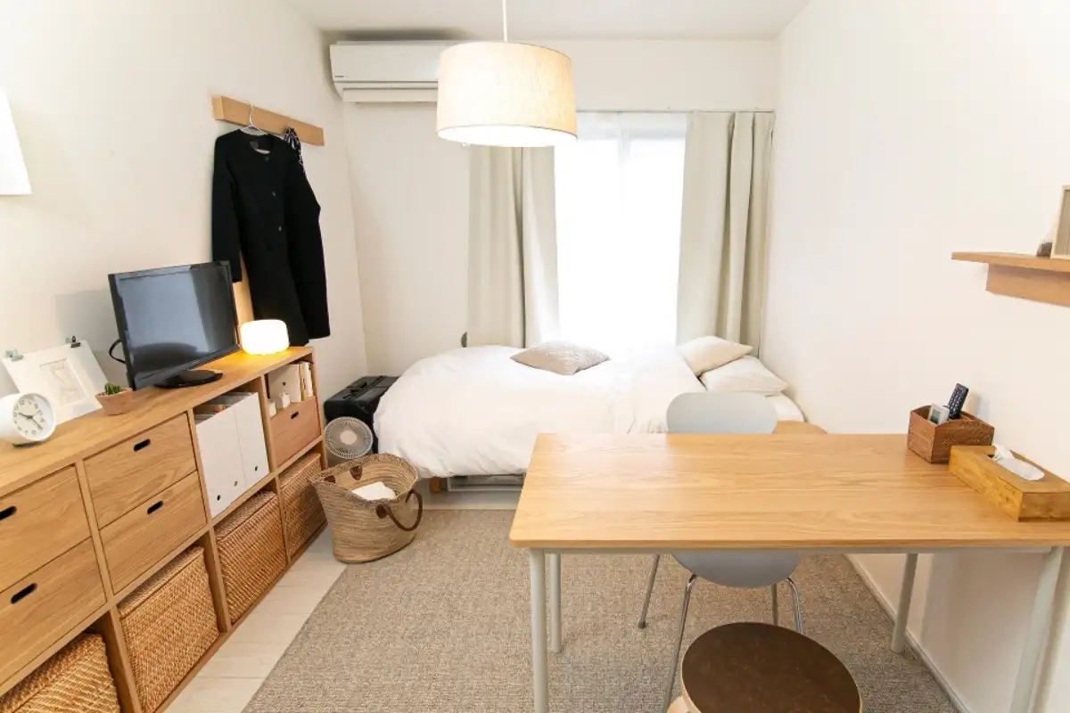 Phòng ngủ tối giản do MUJI thiết kế với giường gỗ, bàn làm việc và trang trí tông màu trung tính