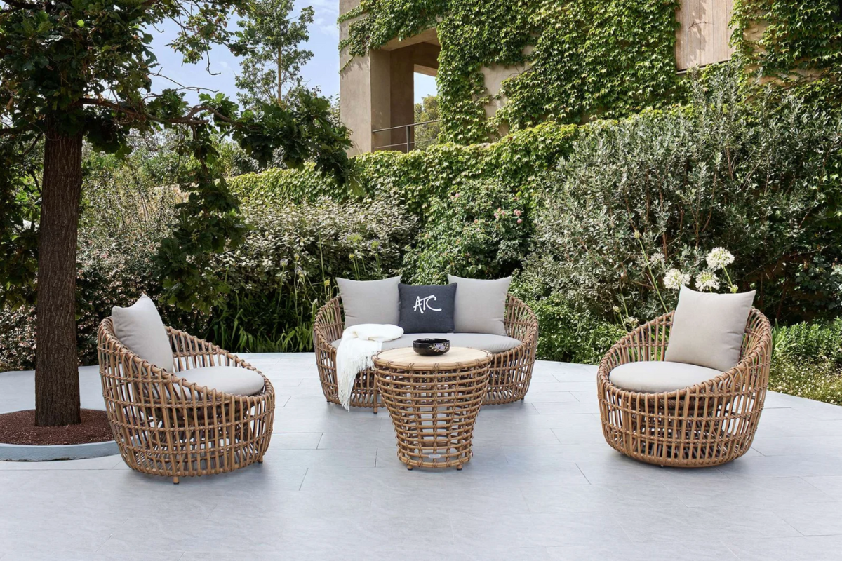 Classic luxury outdoor furniture featuring curved silhouettes and plush cushions in a heritage-inspired setting
