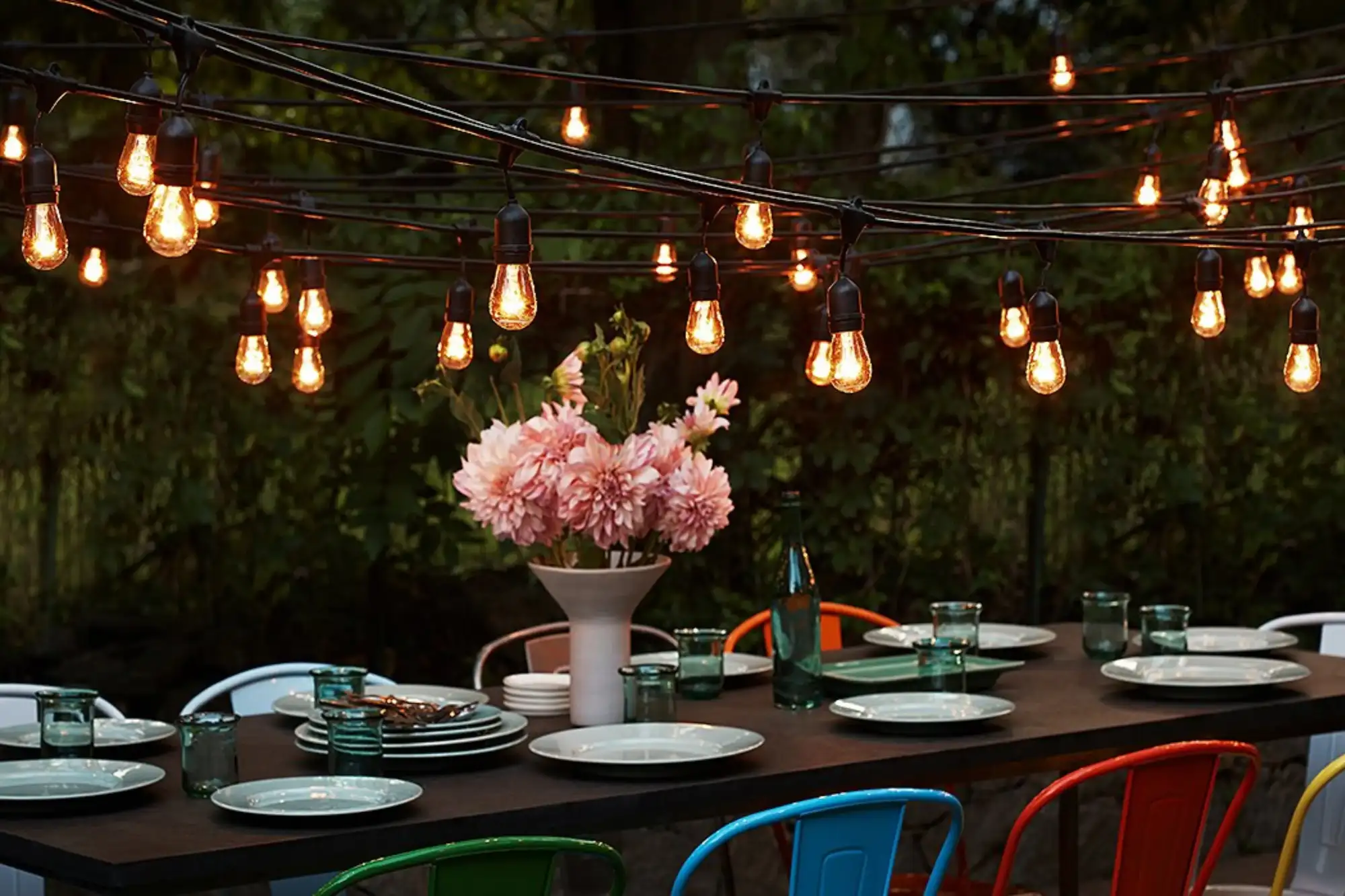 Khu vực bàn ăn ngoài trời rực sáng dưới những dây đèn treo, tạo cảm giác ấm cúng và lãng mạn.