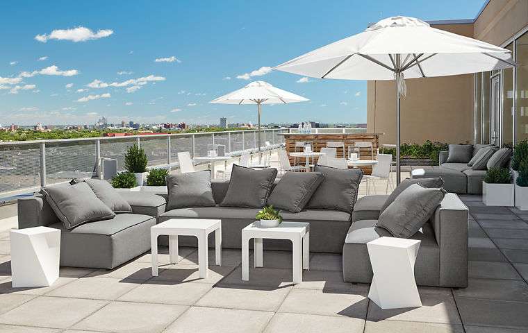 Modern outdoor space featuring a large sectional sofa and convenient side tables