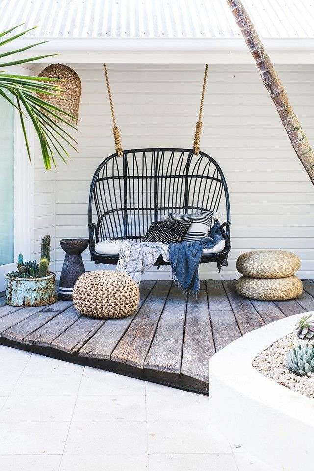 Cozy outdoor corner with a double swing chair and wooden flooring