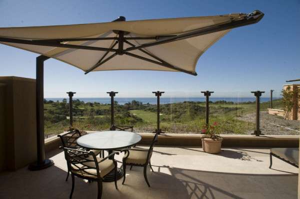 Spacious rooftop corner with outdoor furniture and a scenic mountain backdrop