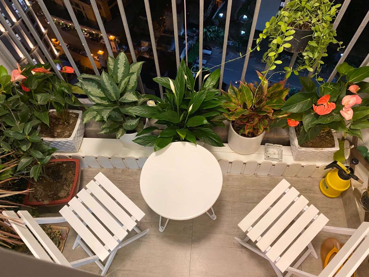 Compact balcony area with outdoor furniture and decorative greenery