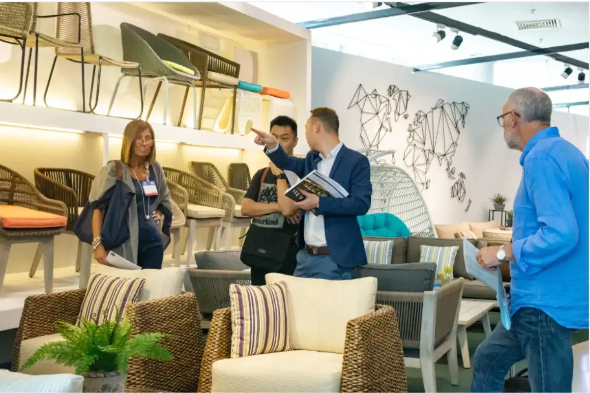 International buyers comparing PE rattan outdoor furniture in a Vietnam showroom