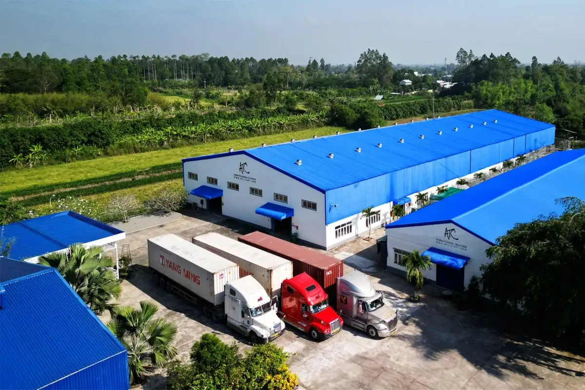 Nhà máy sản xuất nội thất tại Quy Nhơn với quy mô lớn, nhiều container và xe tải chuẩn bị vận chuyển hàng hóa xuất khẩu.  