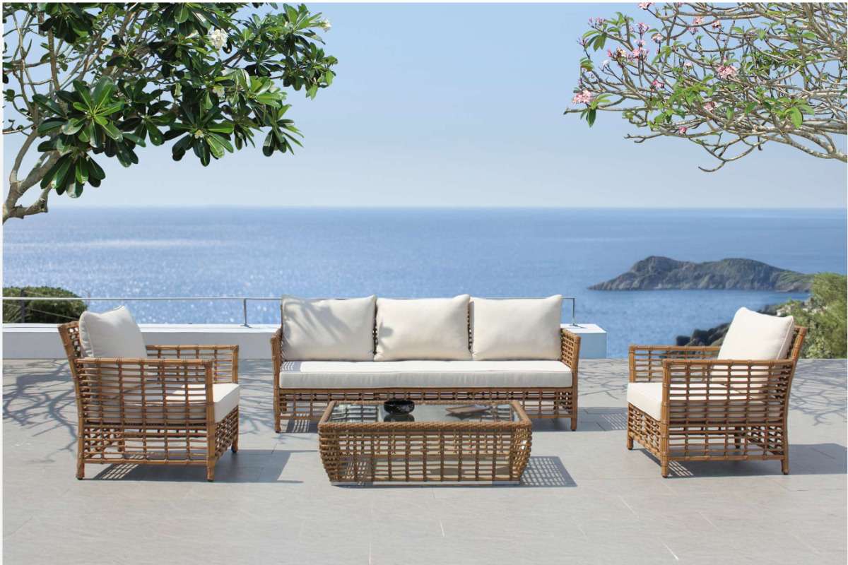 Eco-friendly PE rattan outdoor sofa set on a seaside terrace, symbolizing sustainable, recyclable materials in modern furniture.