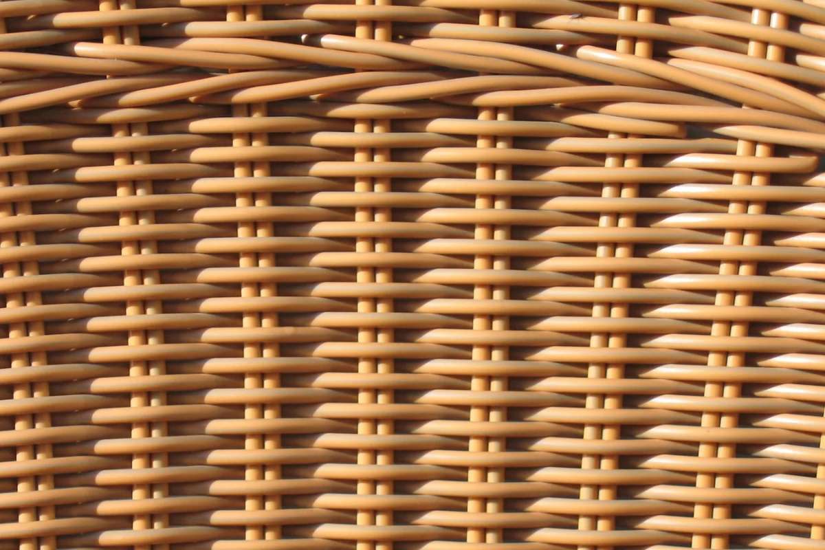 Close-up of synthetic PE rattan weave in a warm brown tone, showing the uniform, weather-resistant fibers used for outdoor furniture.