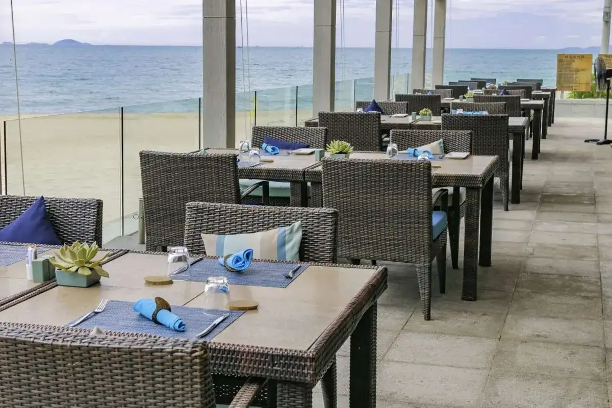 Outdoor dining area at a beachfront resort furnished with HDPE wicker tables and chairs.