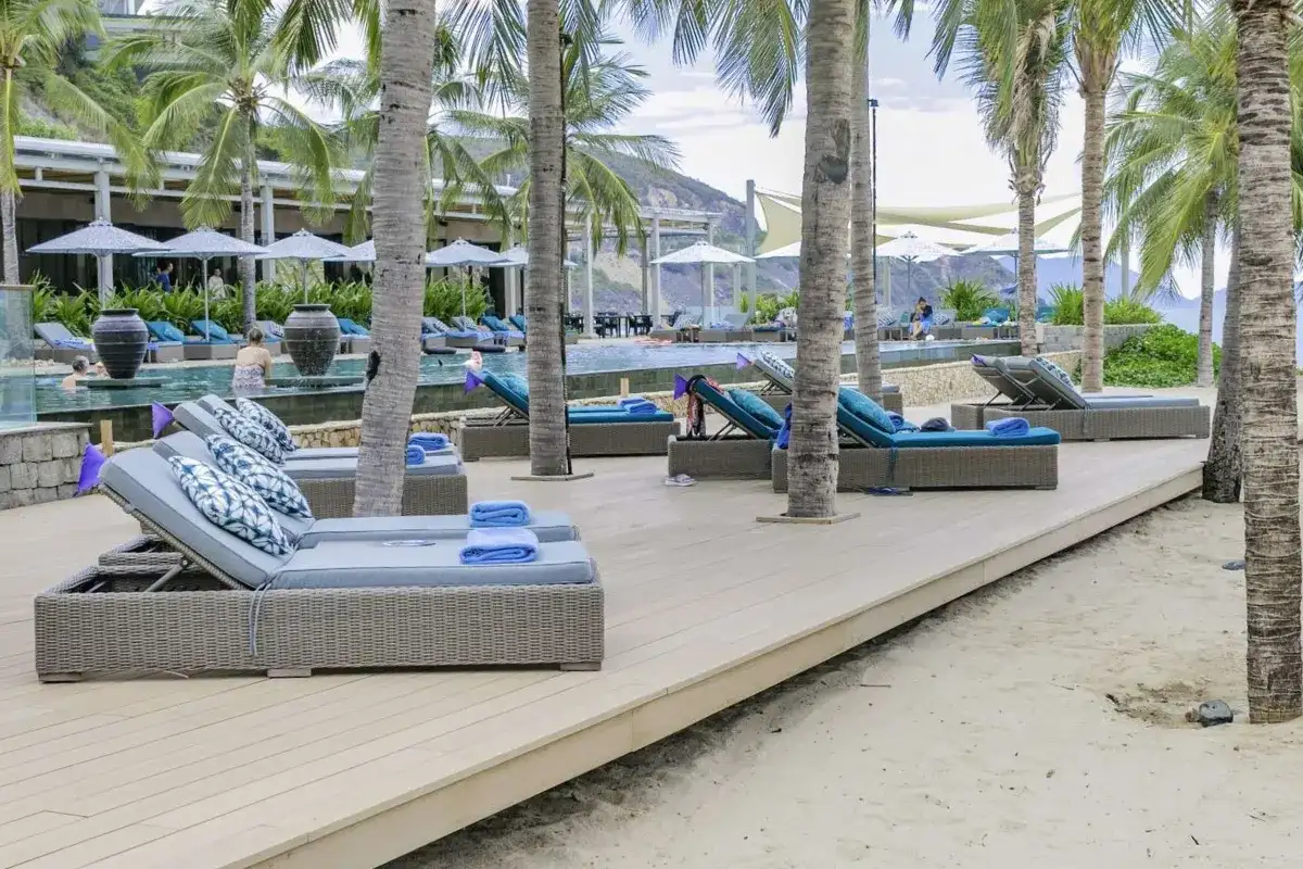 HDPE wicker sun loungers arranged beside a resort swimming pool.