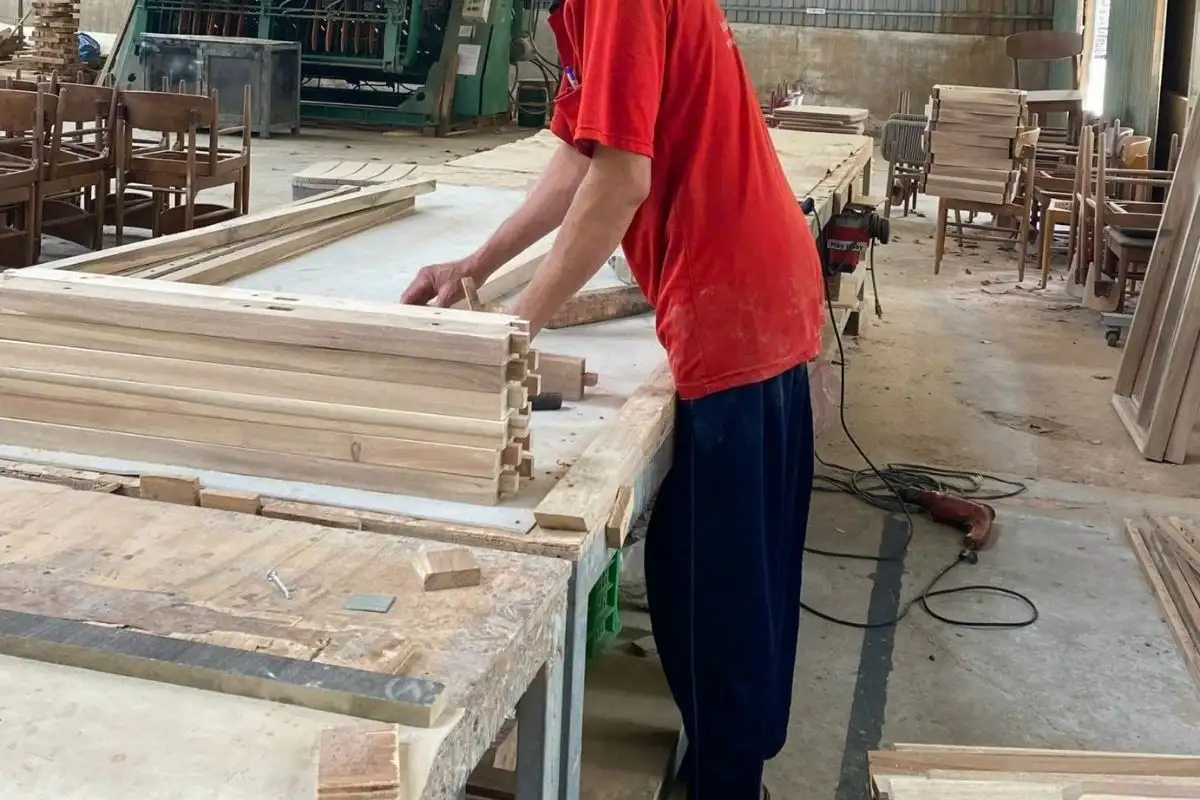 Craftsman at ATC Furniture factory working on wooden components, ensuring precision and quality in sustainable outdoor furniture production.