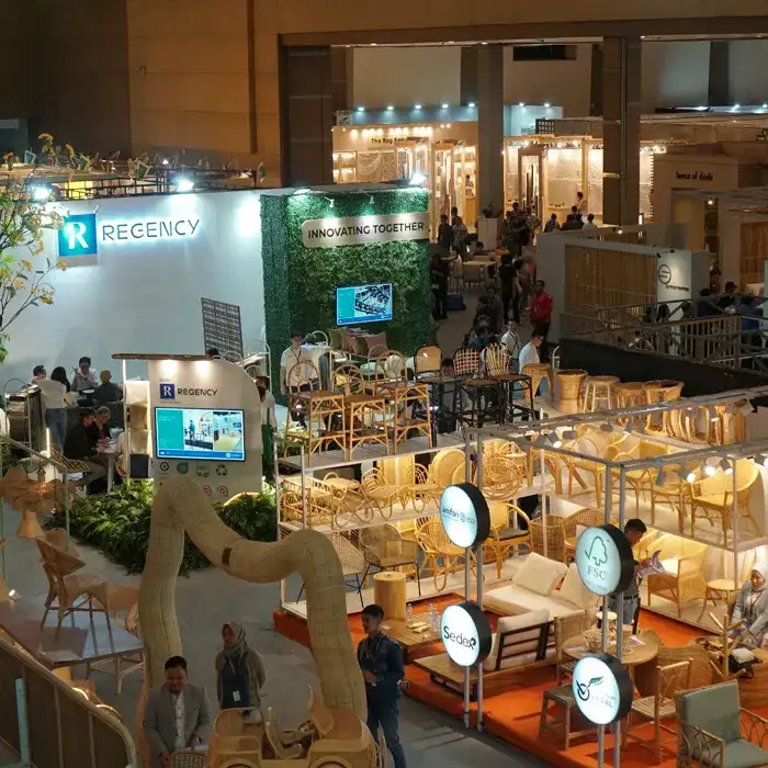 Interior view of IFEX exhibition hall in Jakarta showing well-designed furniture booths, warm lighting, and international buyers meeting exporters.