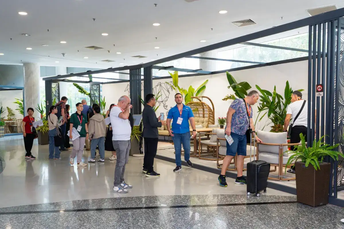  International visitors exploring a furniture booth at VIFA Expo Vietnam with displayed rattan and wooden seating collections