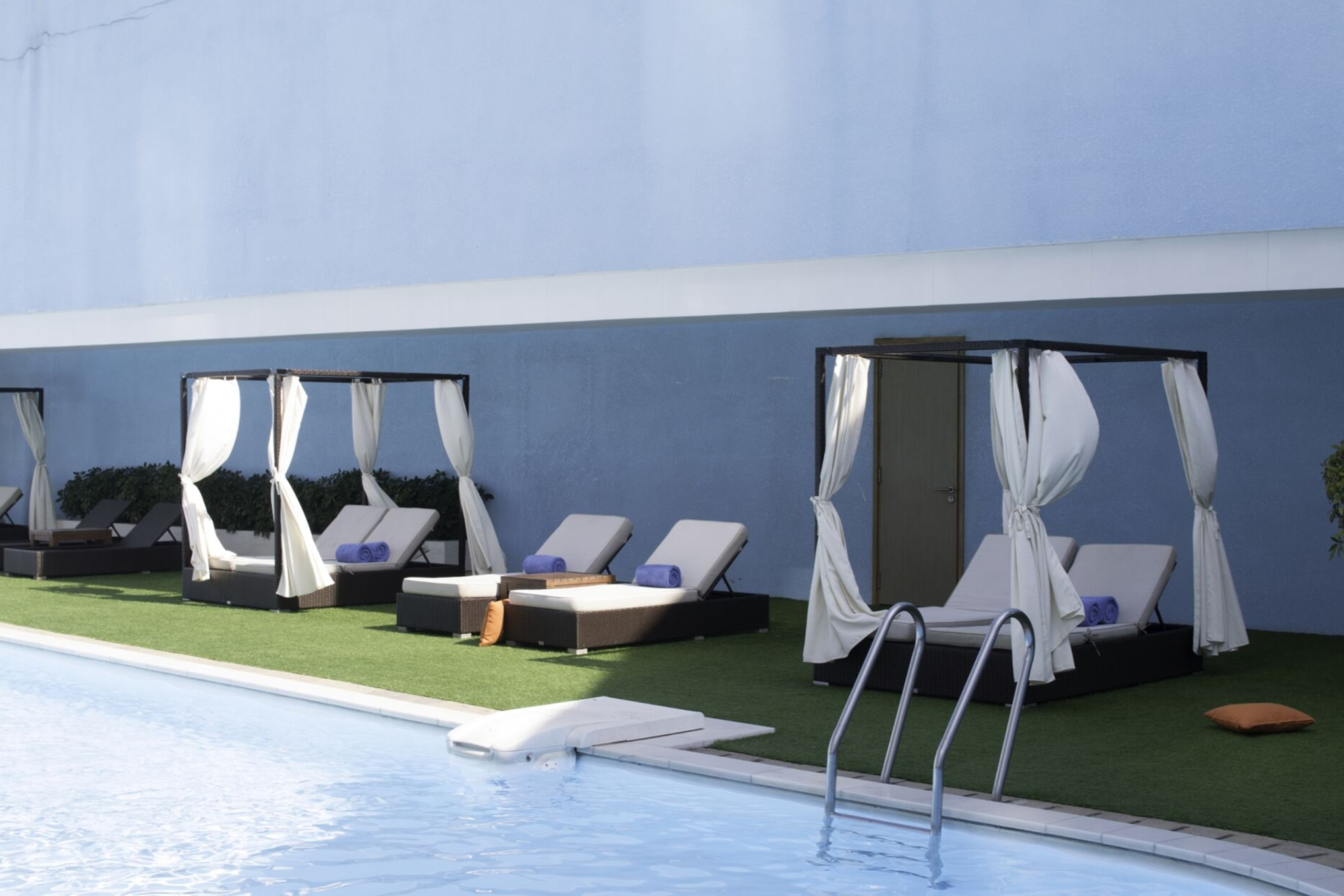 Stylish patio lounge chairs with soft cushions, providing relaxation and ergonomic support for hotel guests.