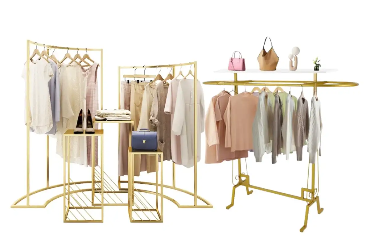 Đồ đạc quần áo với thanh treo màu vàng và bàn lồng trưng bày quần áo, giày dép và túi xách trong một bố cục bán lẻ có tổ chức.