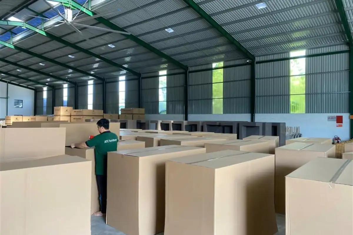 Nhân viên của ATC Furniture quản lý các thùng carton đã đóng gói trong kho, chuẩn bị vận chuyển cho việc giao hàng bán lẻ và hậu cần.
