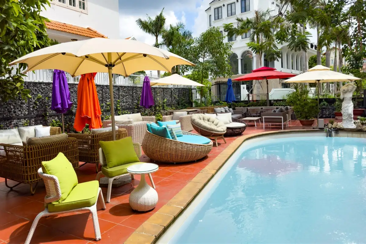 Colorful outdoor furniture with umbrellas arranged around a poolside area, showcasing brand-customized hospitality setup