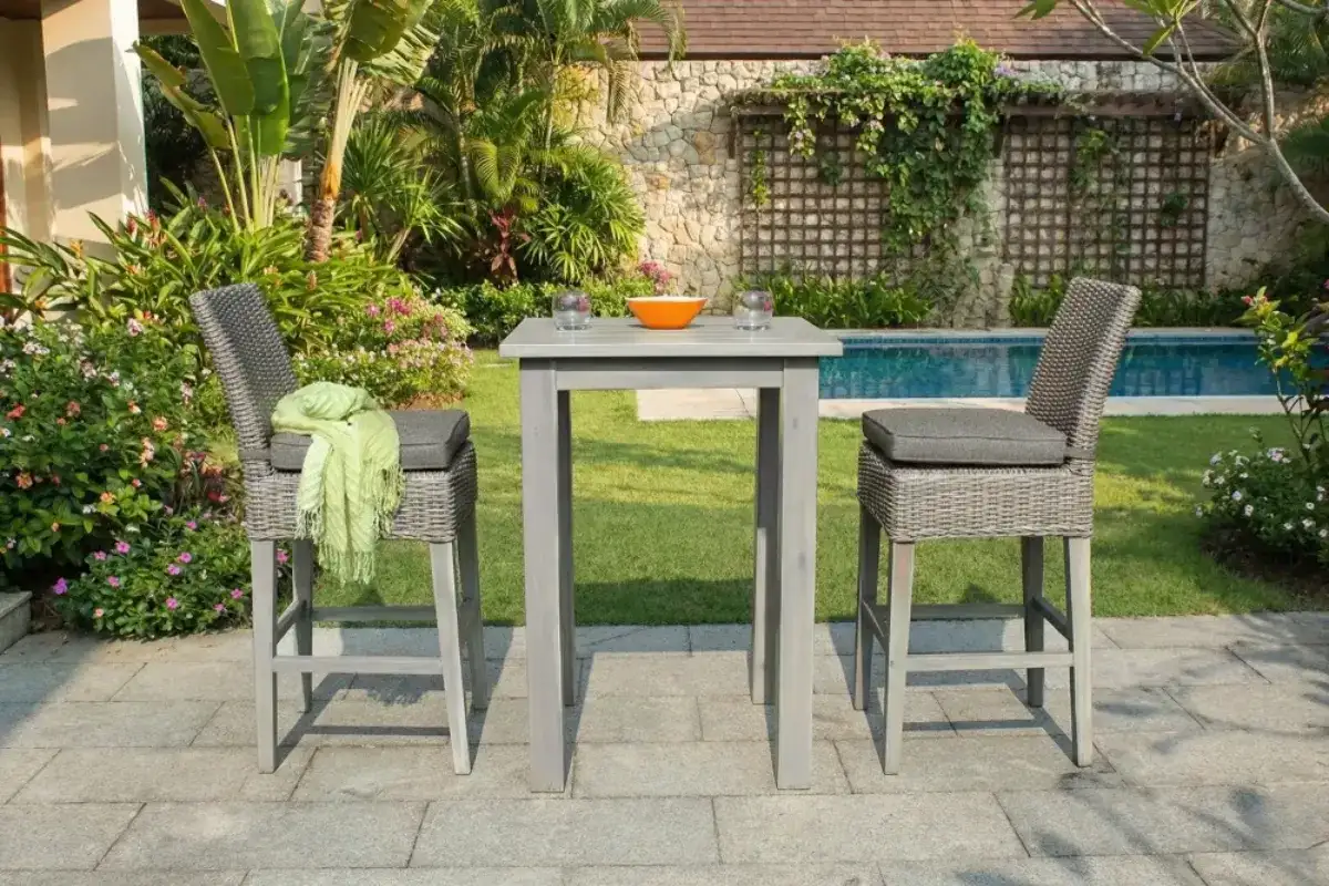 Bộ bàn ghế bar mây nhựa ngoài trời gồm hai ghế cao đặt trong không gian sân vườn