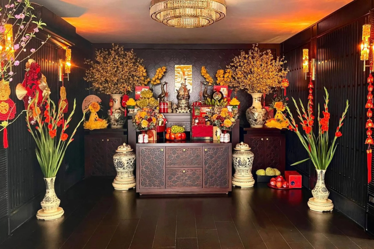 Tet altar decorated with yellow blossoms, red gladiolus, fruit offerings, lanterns, and traditional New Year ornaments