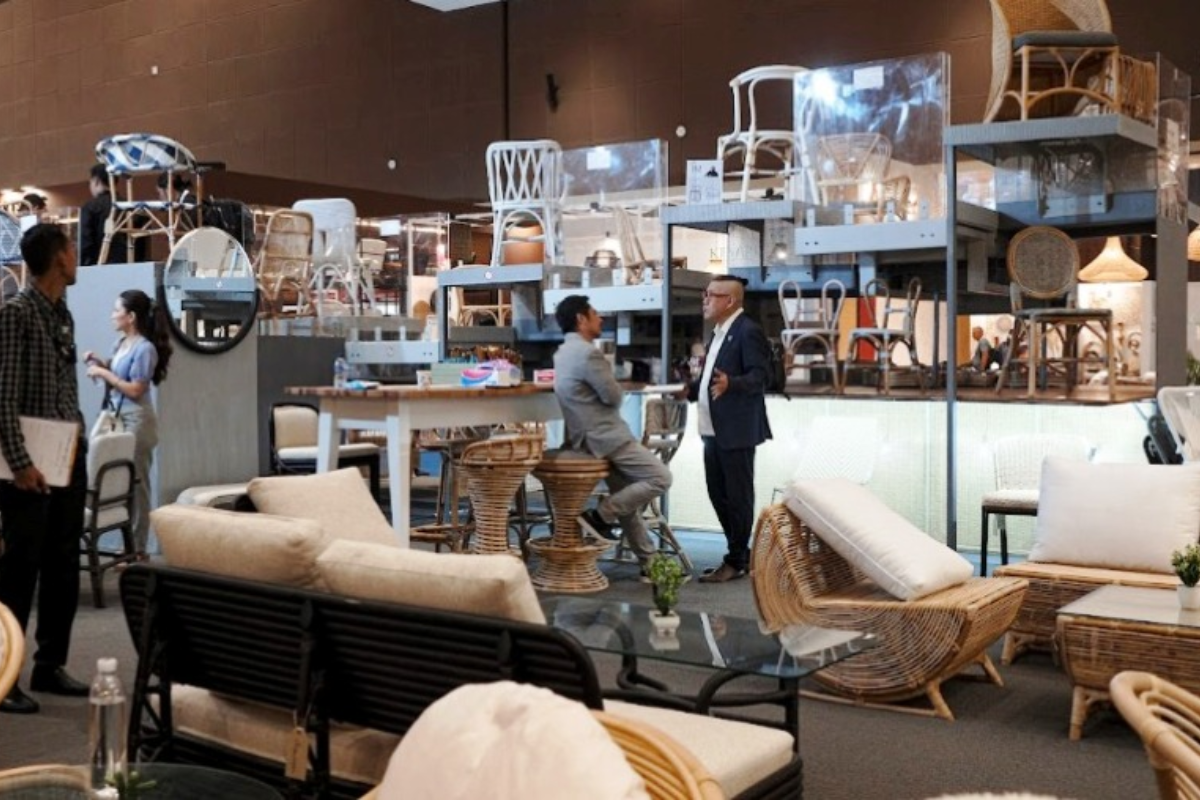 Visitors examining teak and rattan furniture displays at IFEX Southeast Asia furniture fair 