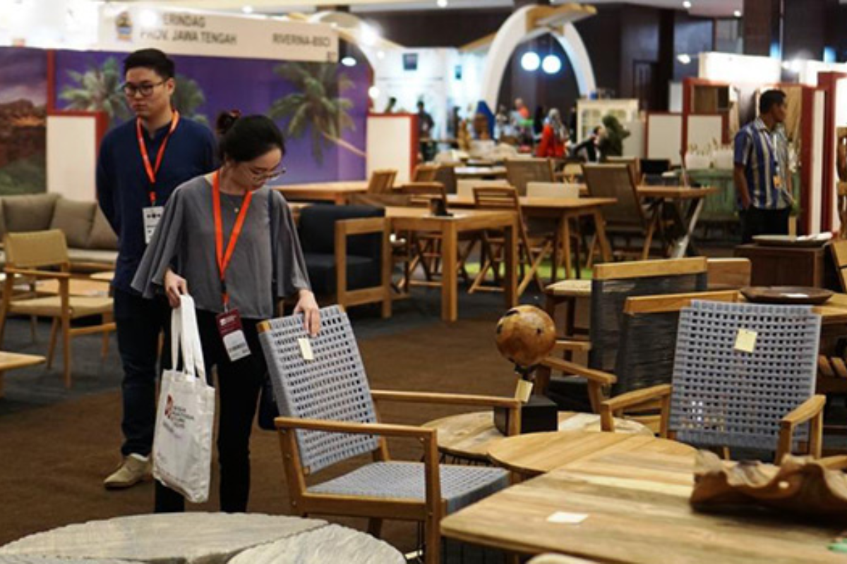 Visitors examining teak and rattan furniture displays at IFEX Southeast Asia furniture fair 