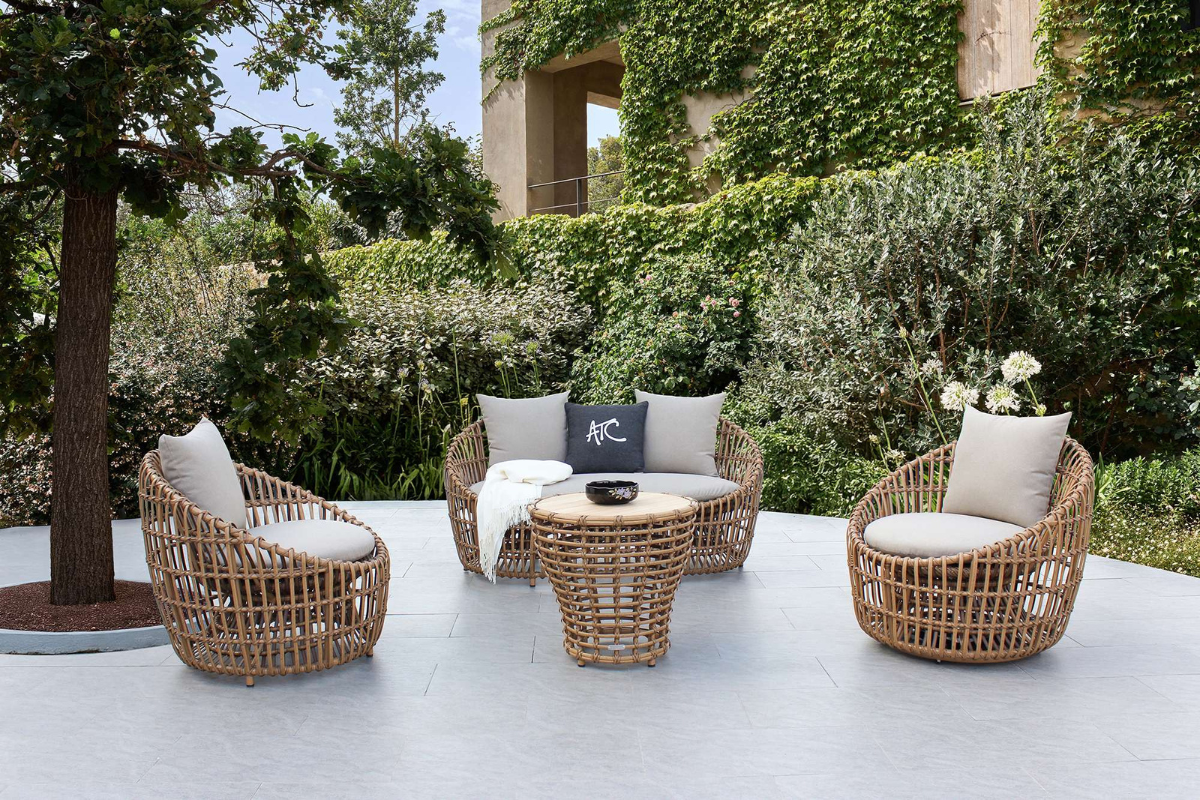 Bộ EMMA với thiết kế bo tròn bằng sợi Poly Bamboo HDPE đan thủ công, kết hợp nệm êm và bàn mặt gỗ teak, tạo nên góc thư giãn hài hòa giữa không gian xanh.