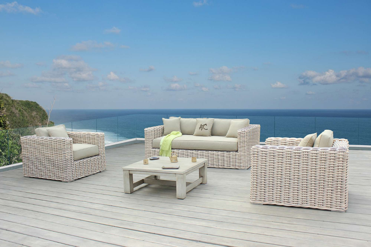 Bộ sofa mây nhựa đan thủ công đặt trên sân hiên hướng biển, sử dụng sợi mây nhựa HDPE và khung nhôm sơn tĩnh điện, mang lại sự bền bỉ và thư giãn cho không gian ngoài trời. ``