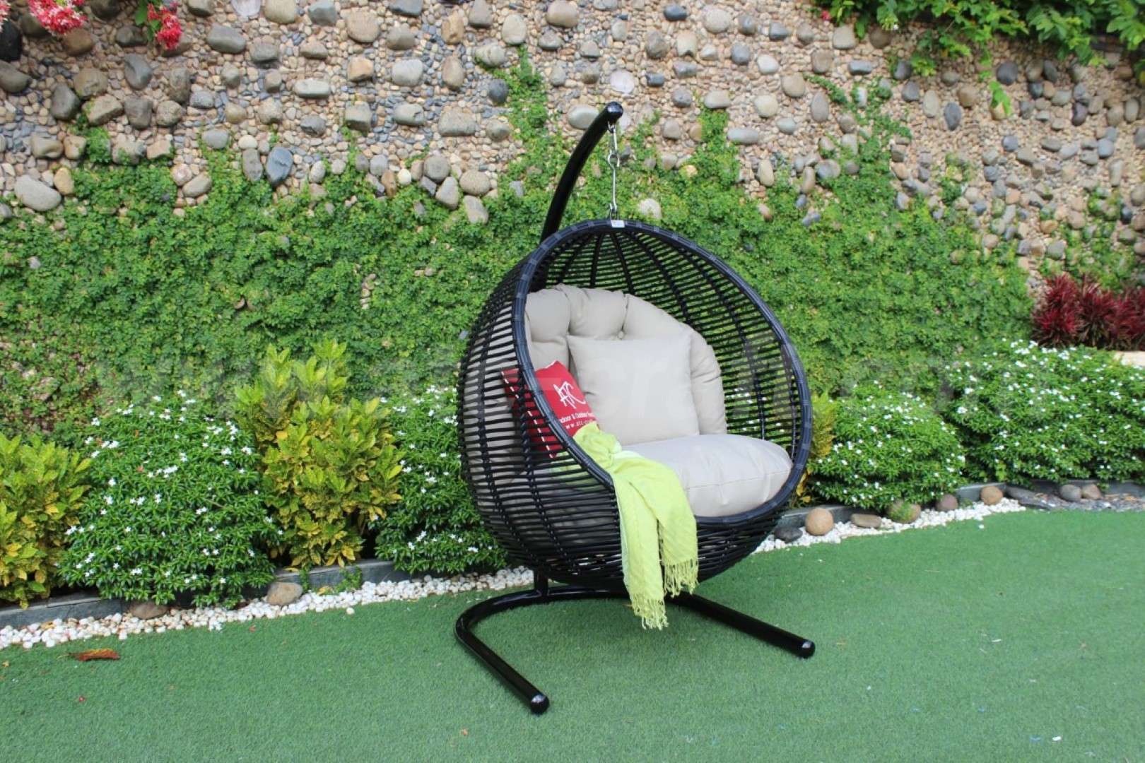 Double swing chair made of poly bamboo in a lush garden.