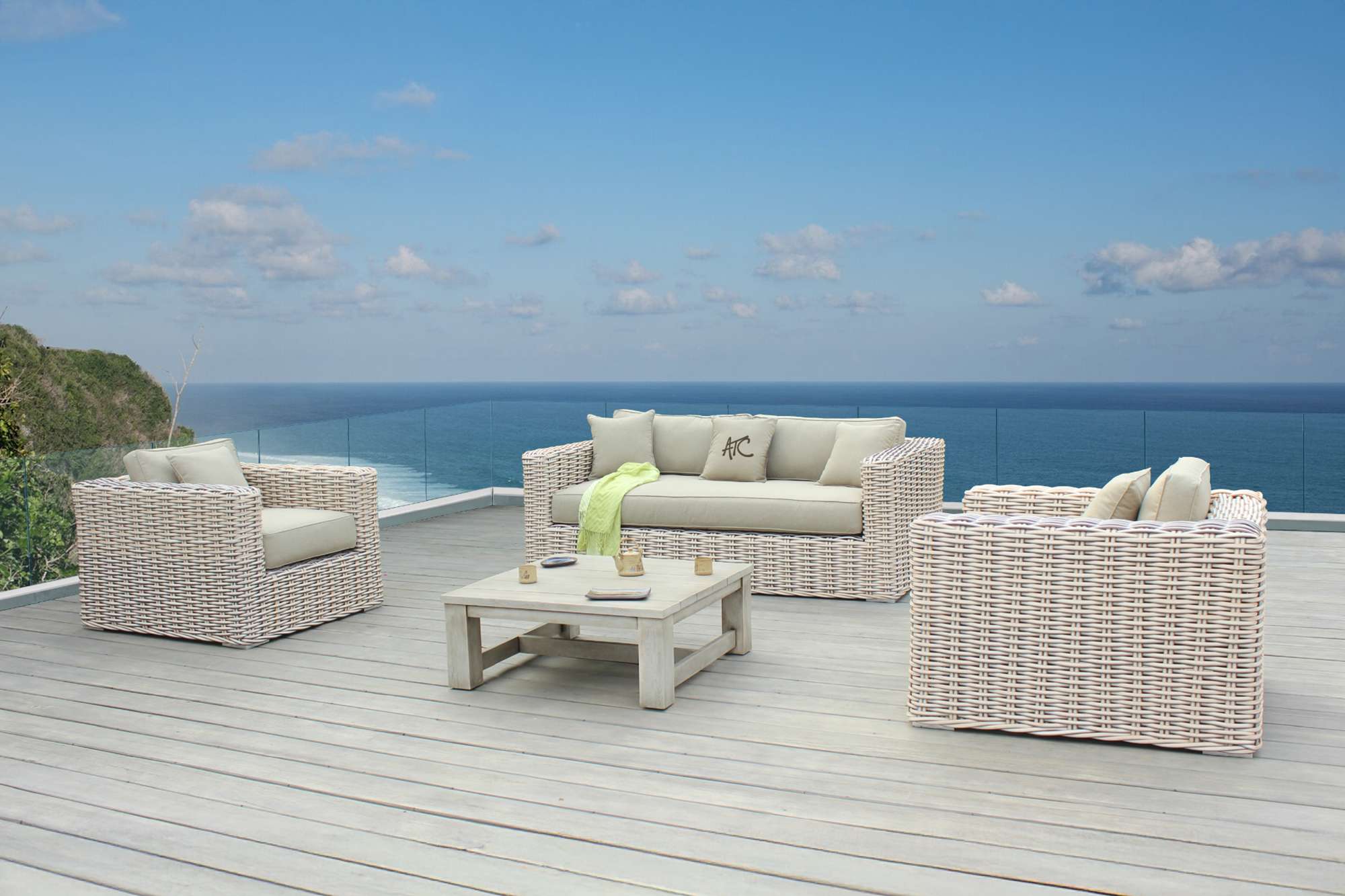 White PE wicker furniture set on a rooftop overlooking the ocean.