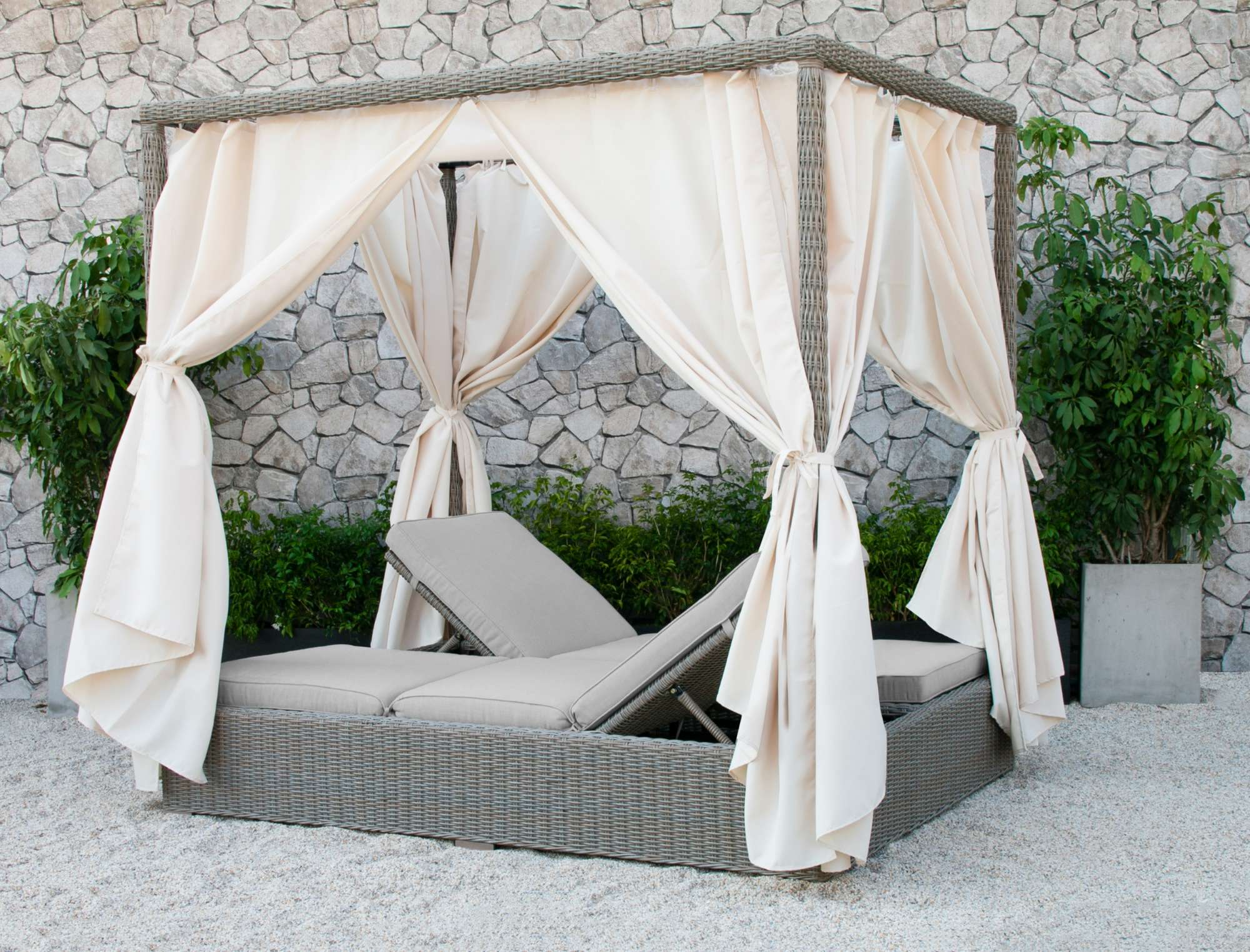 Outdoor daybed with white canopy, offering privacy and comfort.