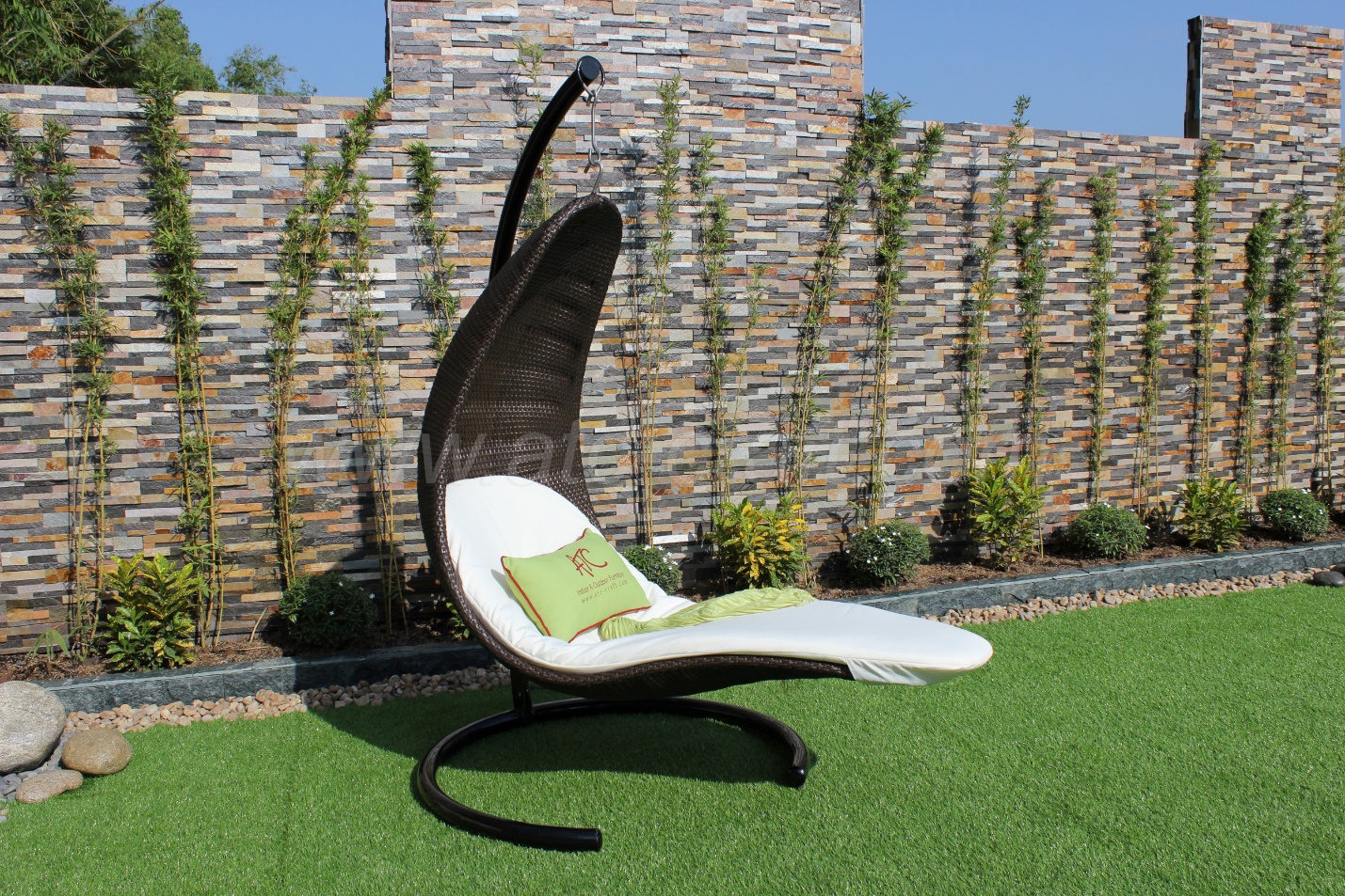 A wicker hanging sun lounger - by ATC Furniture